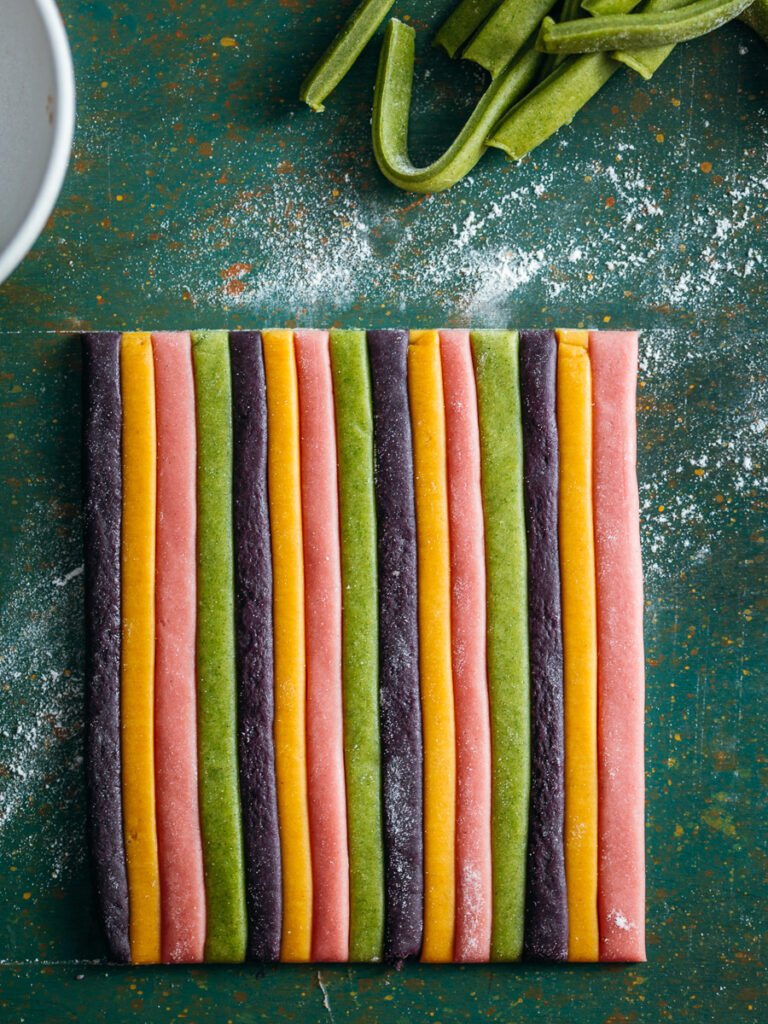 Strisce di pasta fresca colorata accostate per creare la sfoglia a righe