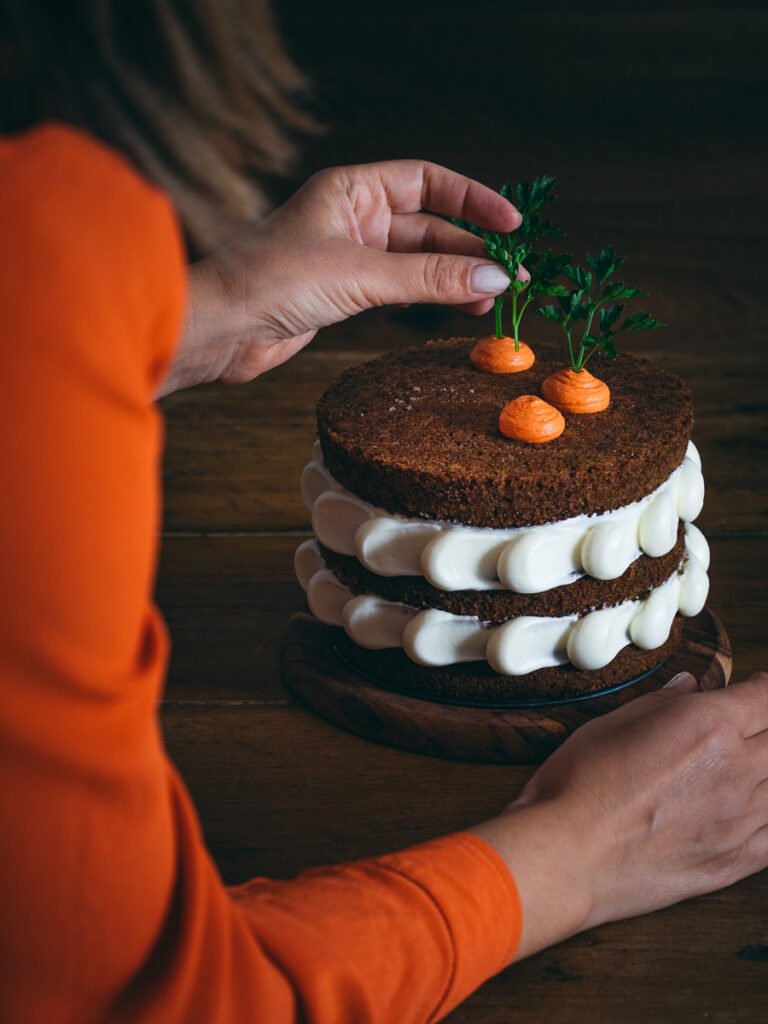torta decorata con frosting bianco e arancione su piatto girevole