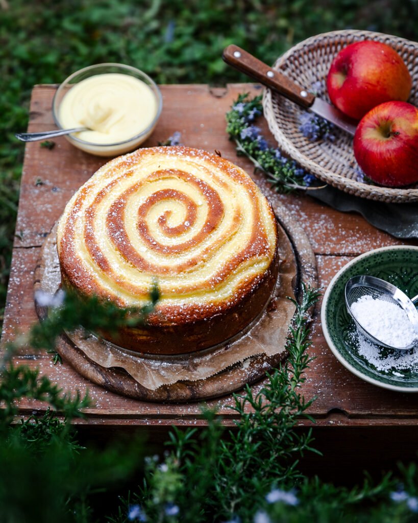 torta di mele e crema pasticcera a spirale vista dall'alto spolverizzata con zucchero a velo